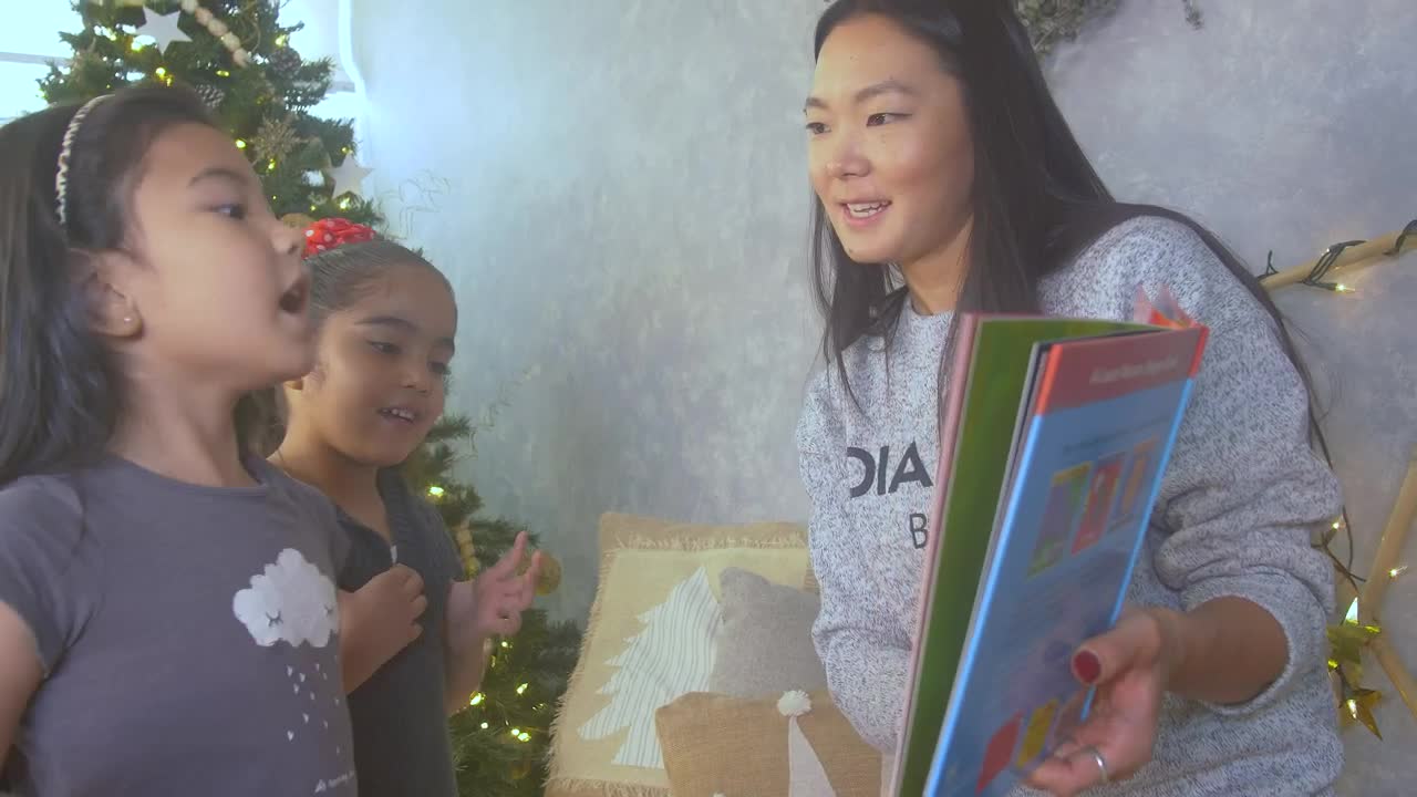 Stock Video Mother Reading A Book With Her Two Daughters At Christma Animated Wallpaper - Free Download