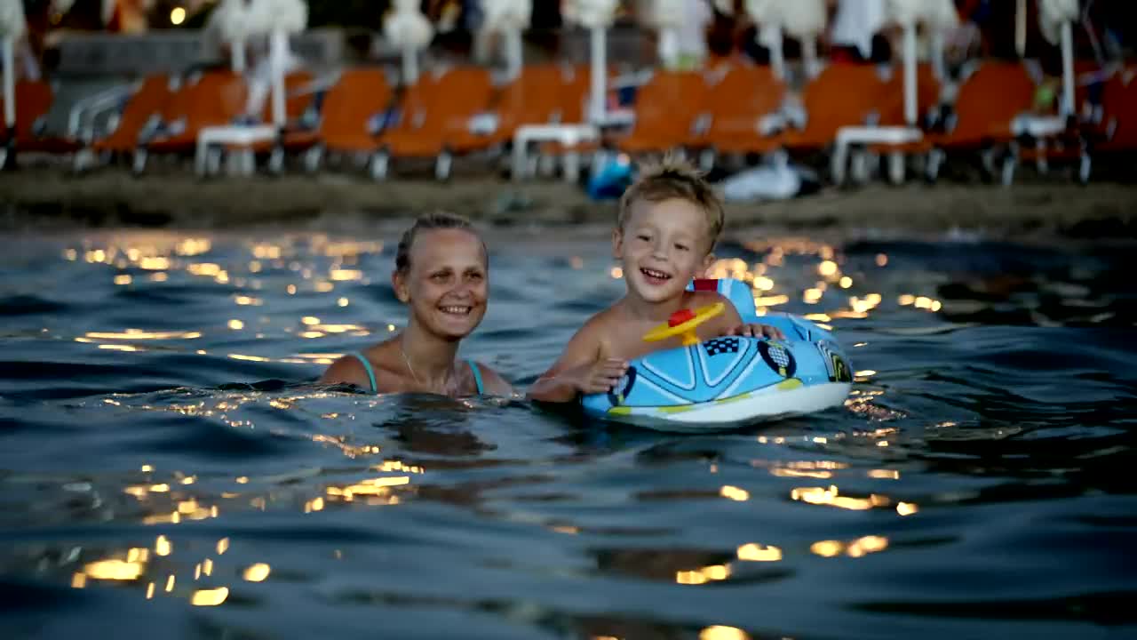 Stock Video Mother And Son With An Inflatable Rin Animated Wallpaper - Free Download