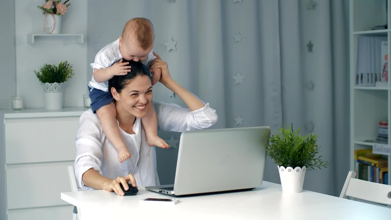 Stock Video Enterprising Mom Plays With Her Baby While Working Live Wallpaper For PC - Free Download