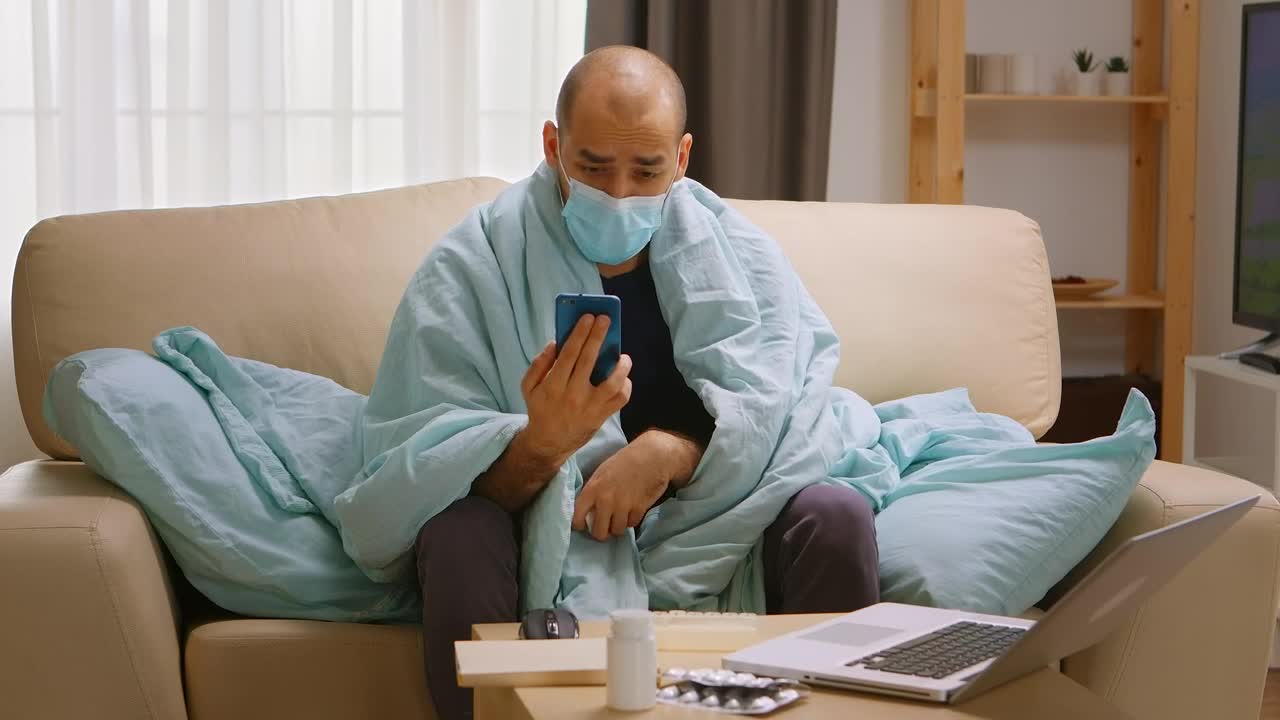 Video Stock Quarantined Man With Smartphone Video Chats On Sofa Live Wallpaper Free - Free Download