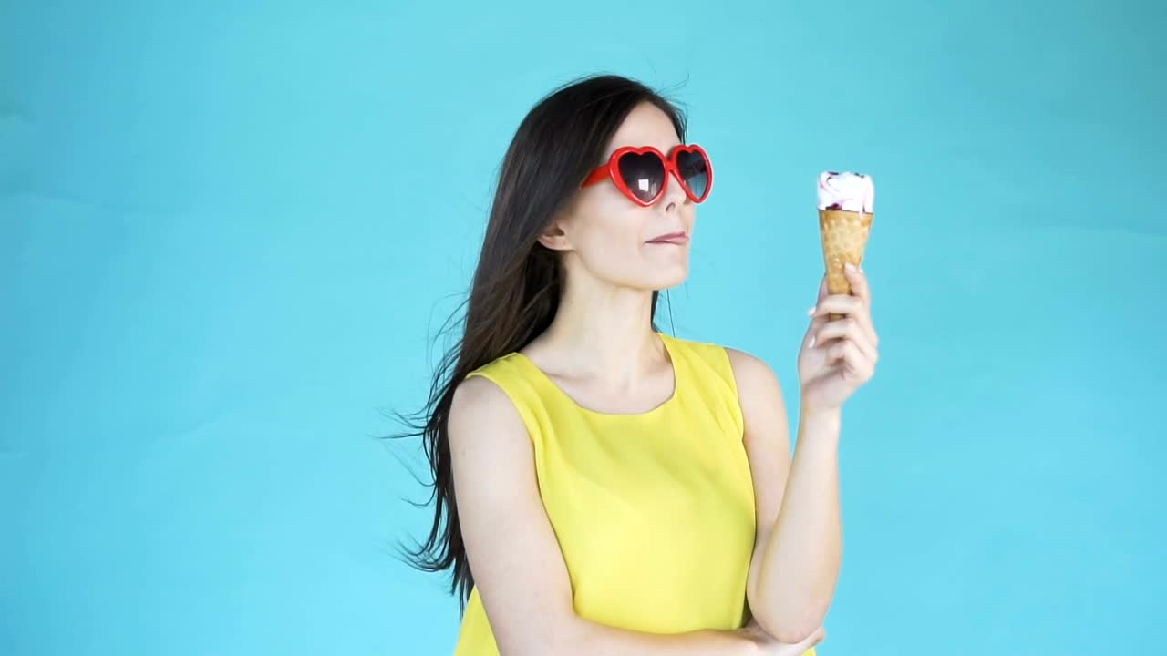 Free Video Stock Smiling Model Holding Ice Cream On Blue Background Live Wallpaper - Free Download