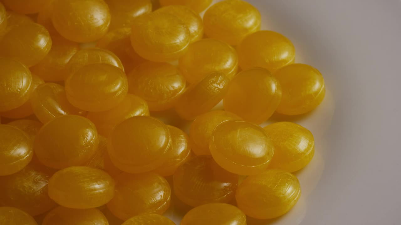 Stock Video Little Yellow Candies Turning Slow On A Plate Animated Wallpaper - Free Download