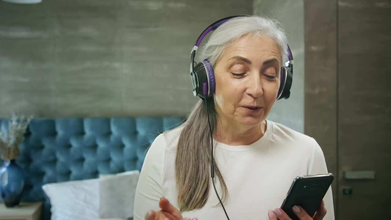 Stock Video Elderly Woman Enjoys Music App With Headphones Live Wallpaper For PC - Free Download