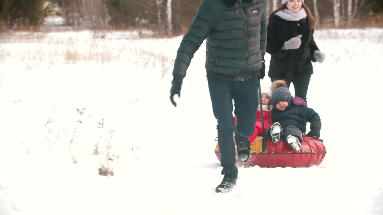 Stock Video Family Playing In The Snow With An Inflatable Sled Live Wallpaper For PC - Free Download