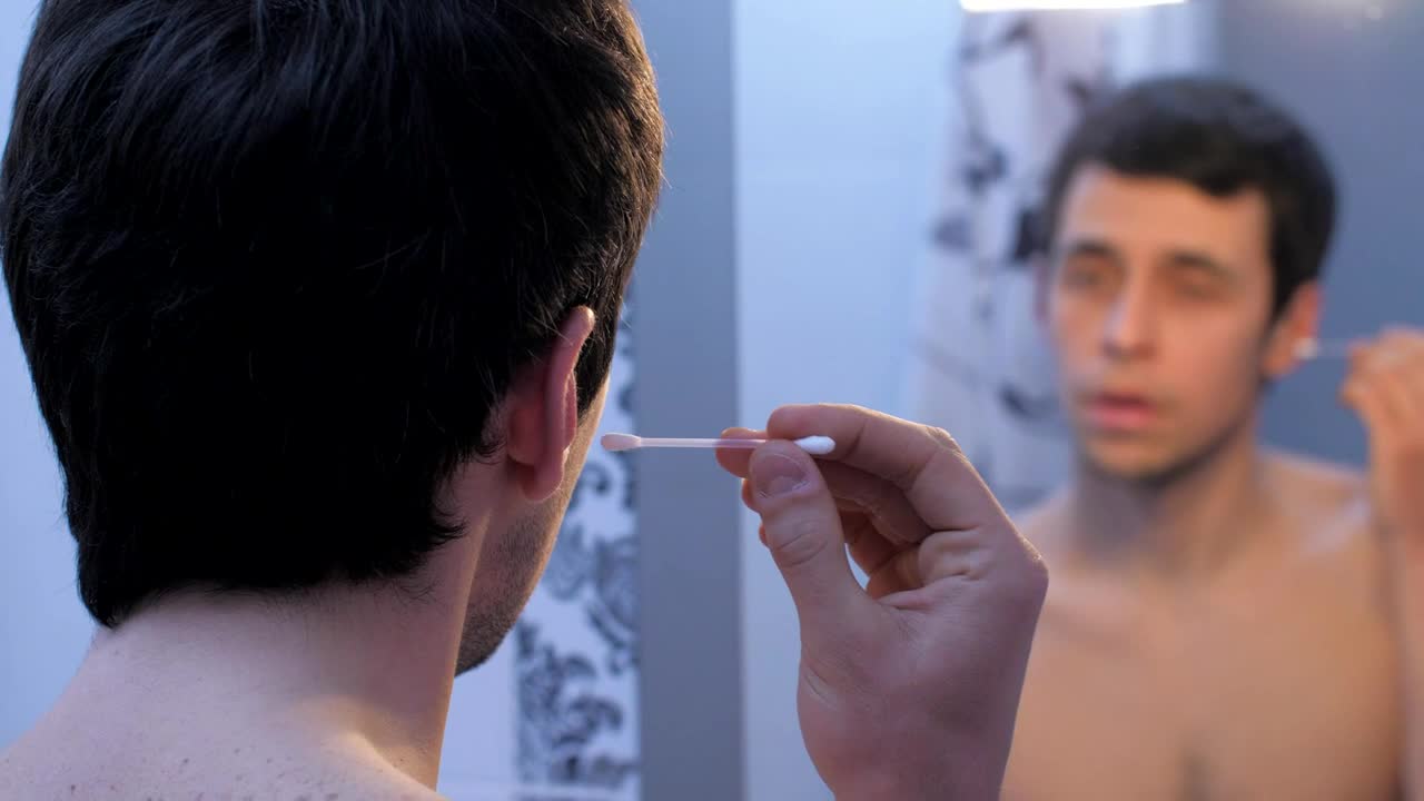 Stock Video Man Cleaning His Ears In The Bathroom Mirror Animated Wallpaper - Free Download