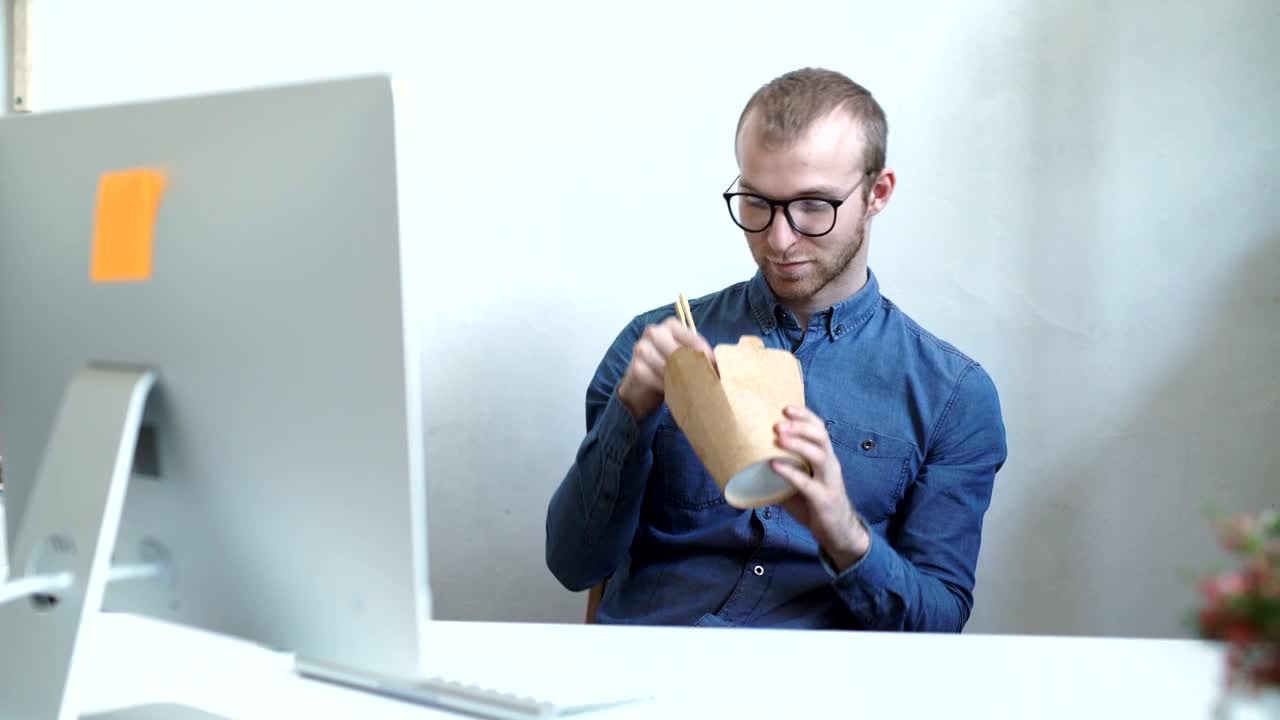 Stock Video Man Eats Chinese Food On Work Break In Office Animated Wallpaper - Free Download