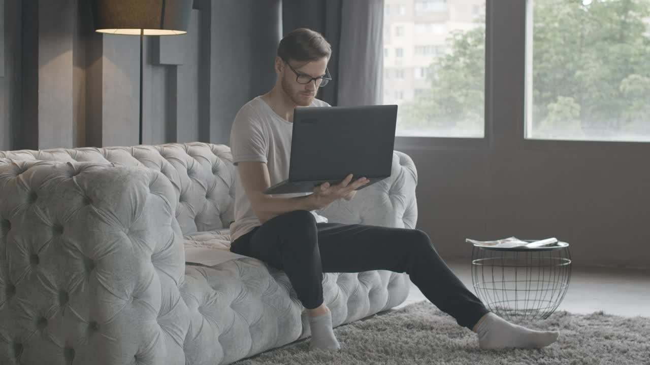 Stock Video Millennial Man Working In Minimalist Living Roo Animated Wallpaper - Free Download