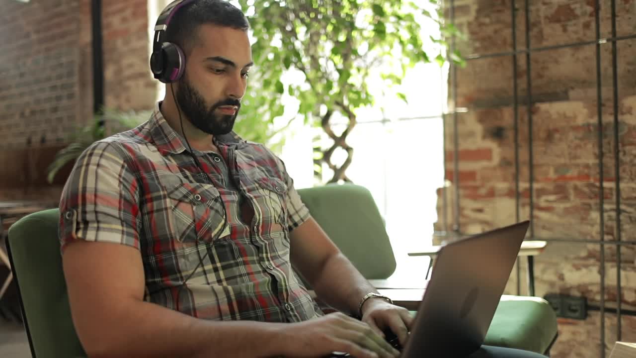 Stock Video Man Works On Laptop With Headphones In Coworking Spac Animated Wallpaper - Free Download