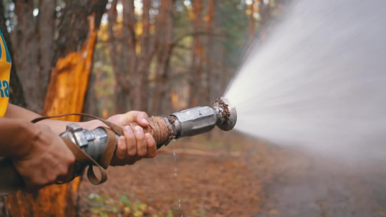 Stock Video Man Holding A Fire Hose In The Woods Animated Wallpaper - Free Download