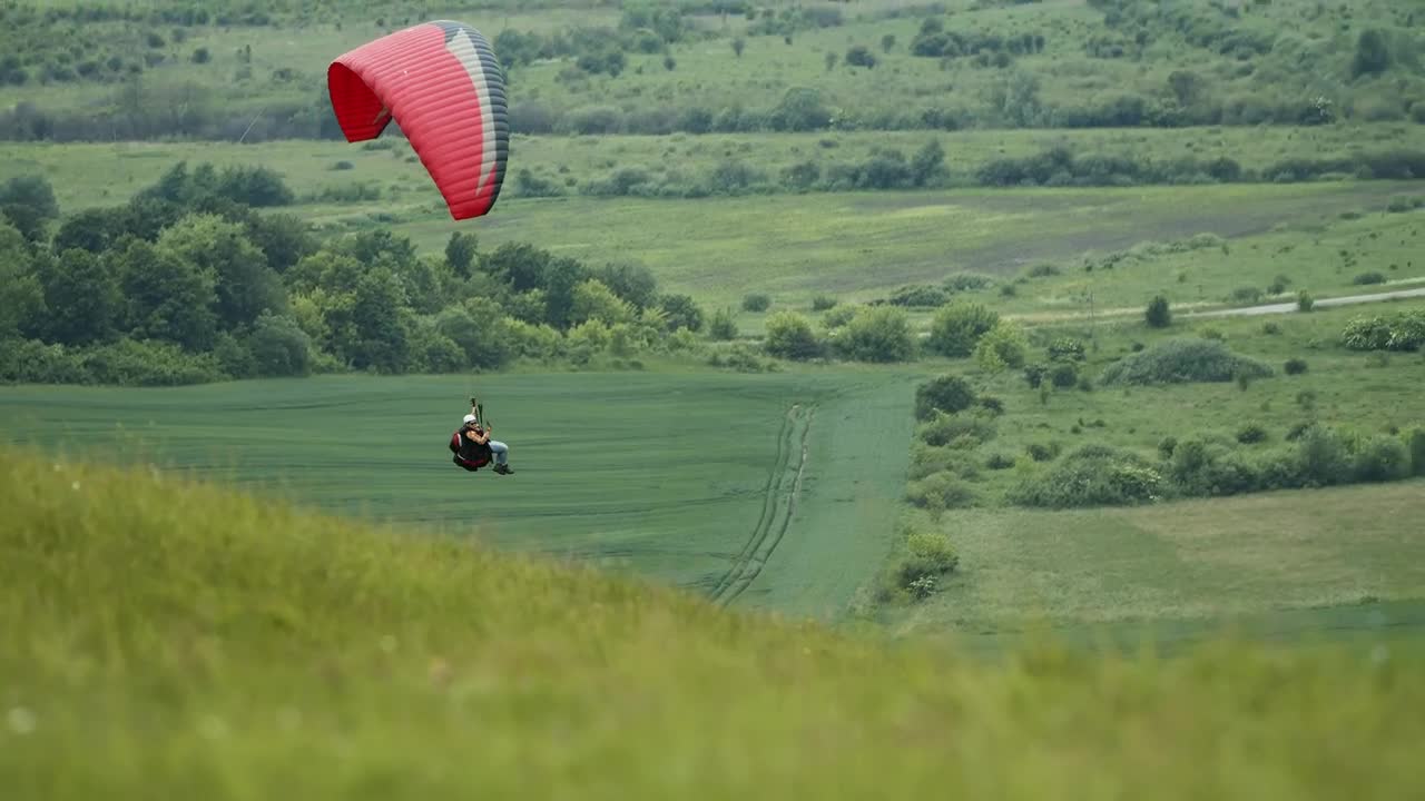 Stock Video Paraglider Floats Over Green Countryside Live Wallpaper - Free Download