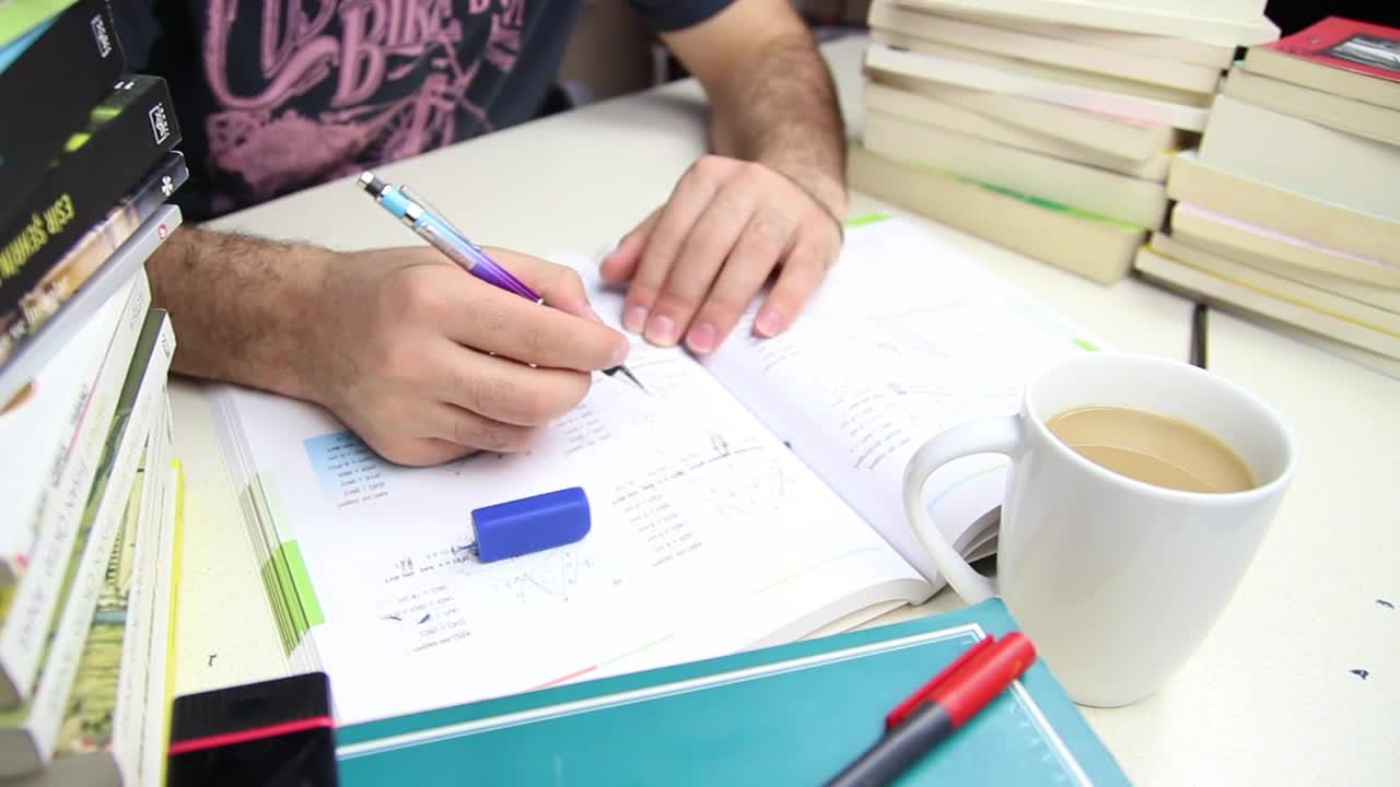 Stock Video Man Studying With A Cup Of Coffee And Many Book Animated Wallpaper - Free Download
