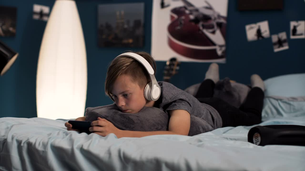 Free Video Stock teen boy playing on his phone on the bed Live Wallpaper - Free Download