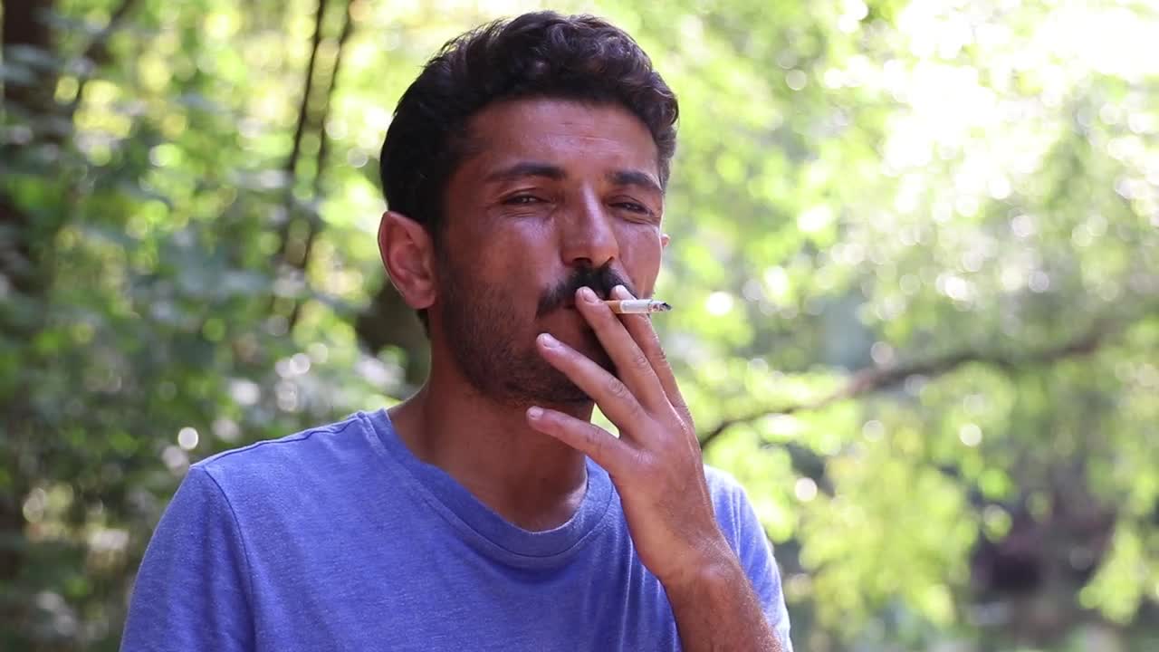 Stock Video Man Smoking Outside Looking Directly To The Camer Animated Wallpaper - Free Download