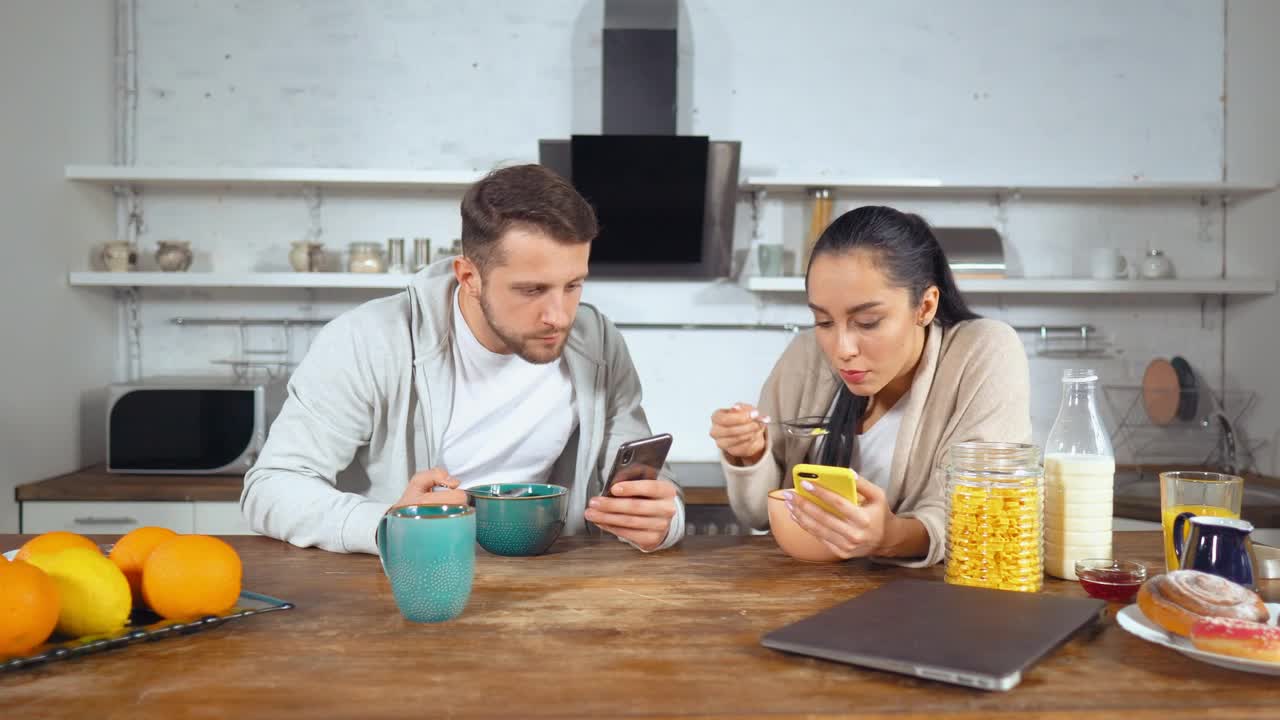Stock Video Couple Having Breakfast Cereal And See Their Cell Phones Live Wallpaper For PC - Free Download