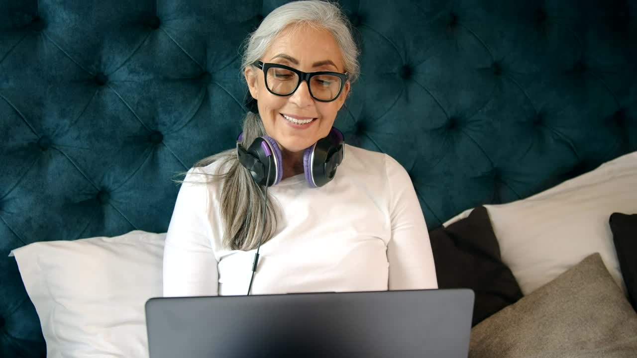 Free Video Stock Smiling Elderly Woman On Laptop In Bed Live Wallpaper - Free Download