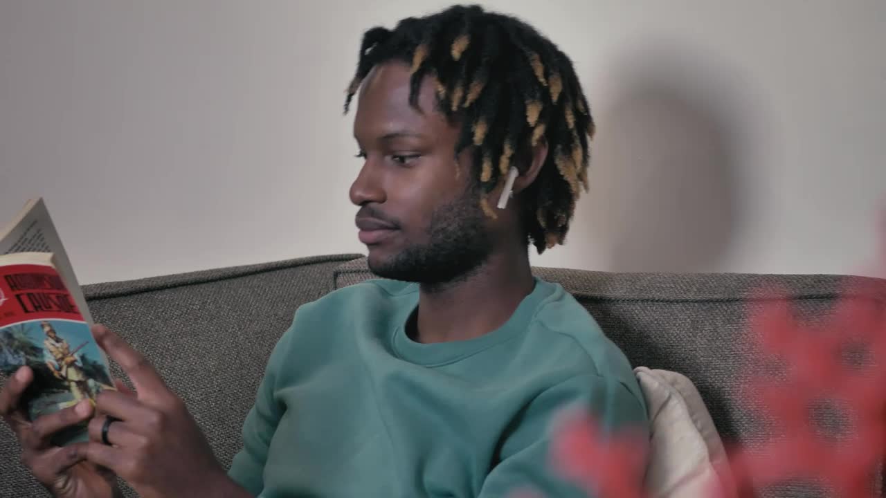Stock Video Man On A Sofa Listening To Music And Reading Animated Wallpaper - Free Download
