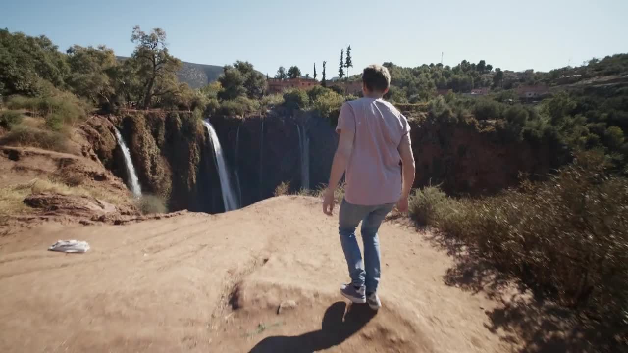 Stock Video Man Walks To A Canyon In Nature With Waterfall Animated Wallpaper - Free Download