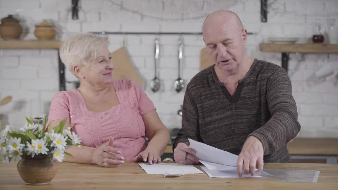 Stock Video Elderly Couple Discuss Bills In Kitchen Live Wallpaper For PC - Free Download