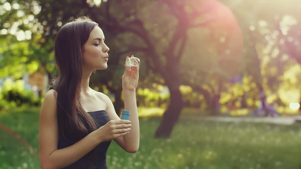 Stock Video Cute Young Woman Blowing Bubbles In The Park Live Wallpaper For PC - Free Download