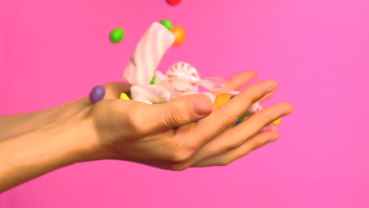 Stock Video Hands Of A Person Full Of Sweets On A Pink Animated Wallpaper - Free Download