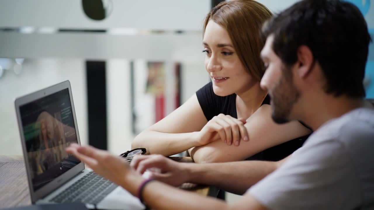 Stock Video Man And Woman Commenting On An Image On A Laptop Animated Wallpaper - Free Download
