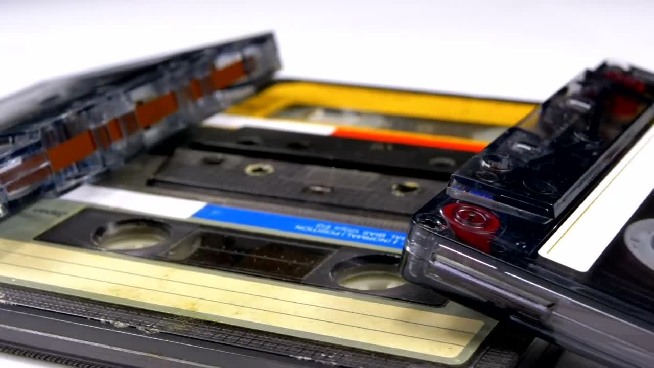 Stock Video Four Audio Cassettes Rotating On A White Surface Live Wallpaper For PC - Free Download