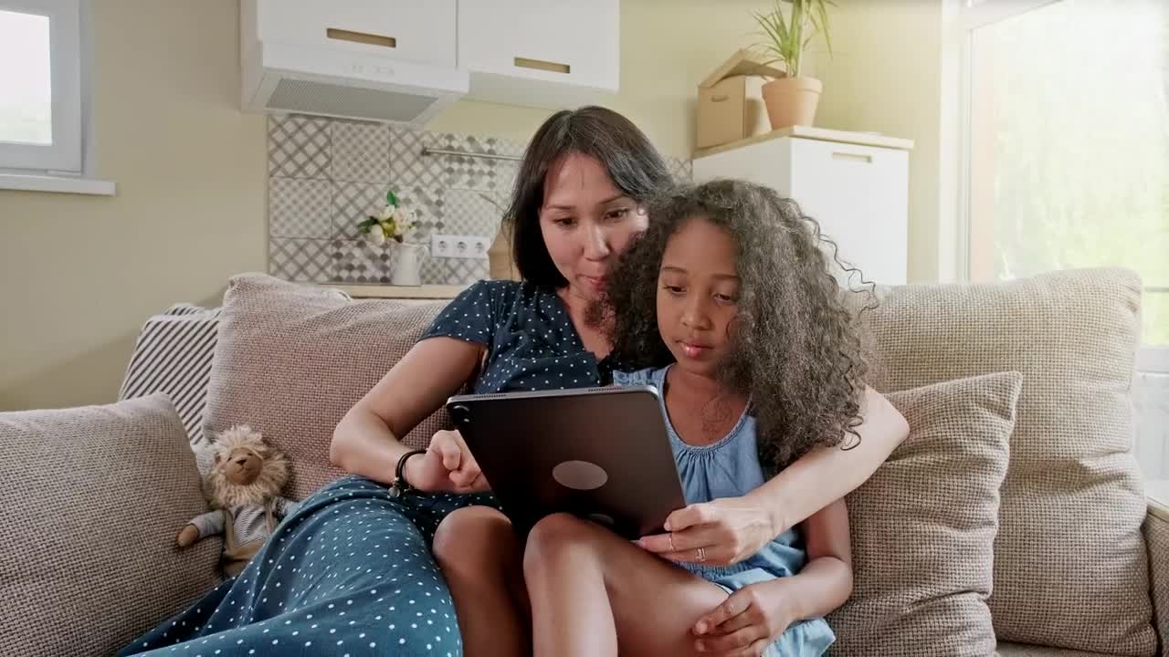 Stock Video Mom And Daughter Use Tablet On Sofa In New Apartmen Animated Wallpaper - Free Download