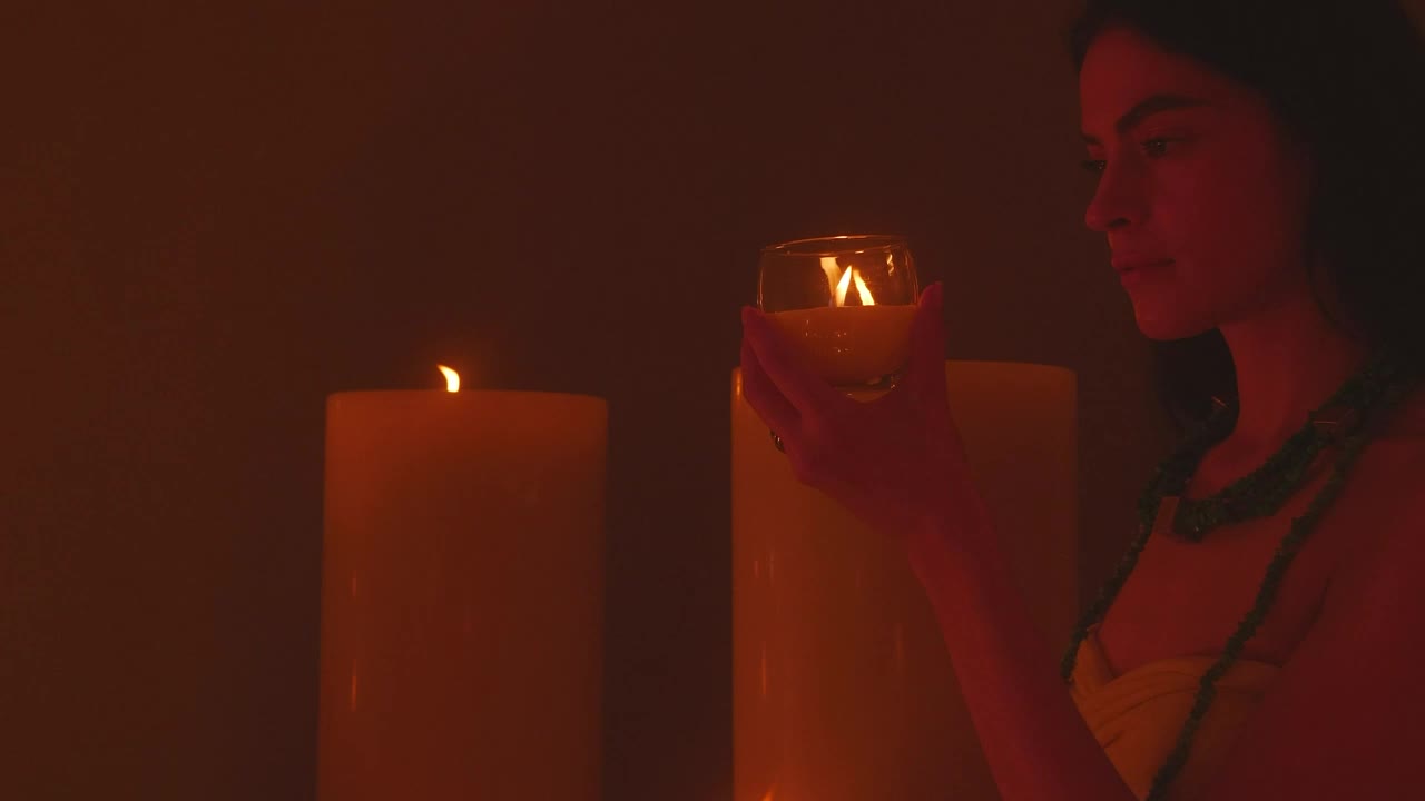 Stock Video Meditative Woman Appreciating A Small Candl Animated Wallpaper - Free Download