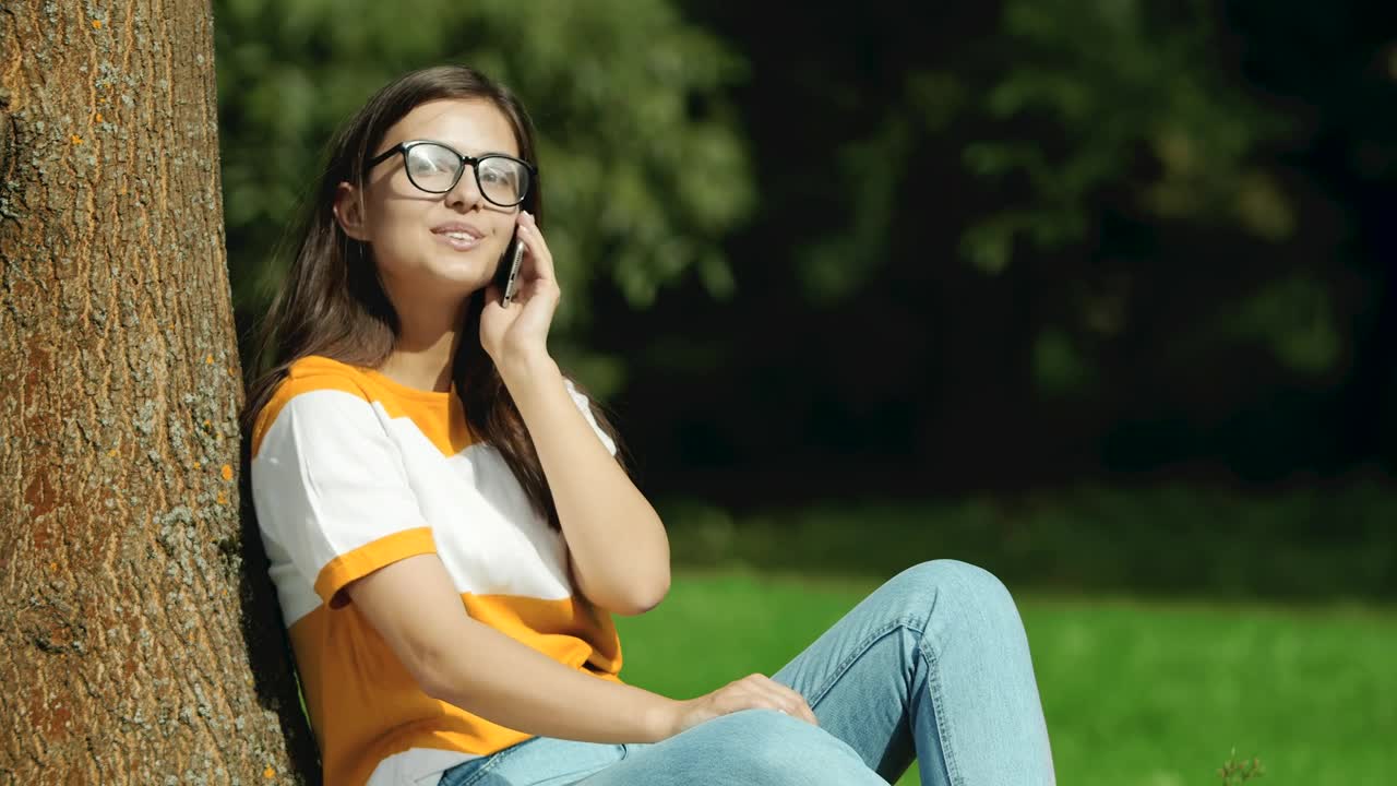 Video Stock Pretty Girl In Glasses Says Hello On Mobile In Park Live Wallpaper Free - Free Download