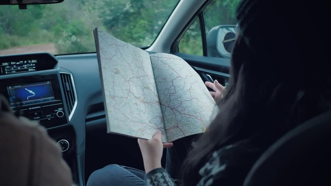 Stock Video Couple Of Adventurers Reading A Map Inside A Car Live Wallpaper For PC - Free Download