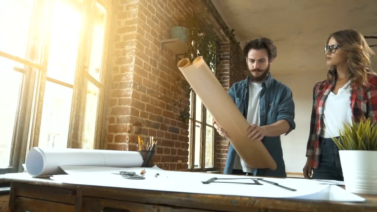 Stock Video Designers Unroll Plans Onto Desk In Studio Live Wallpaper For PC - Free Download