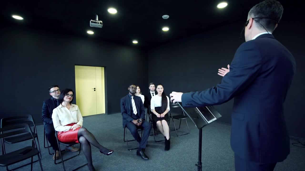 Stock Video Man Speaking In Front Of A Small Audienc Animated Wallpaper - Free Download