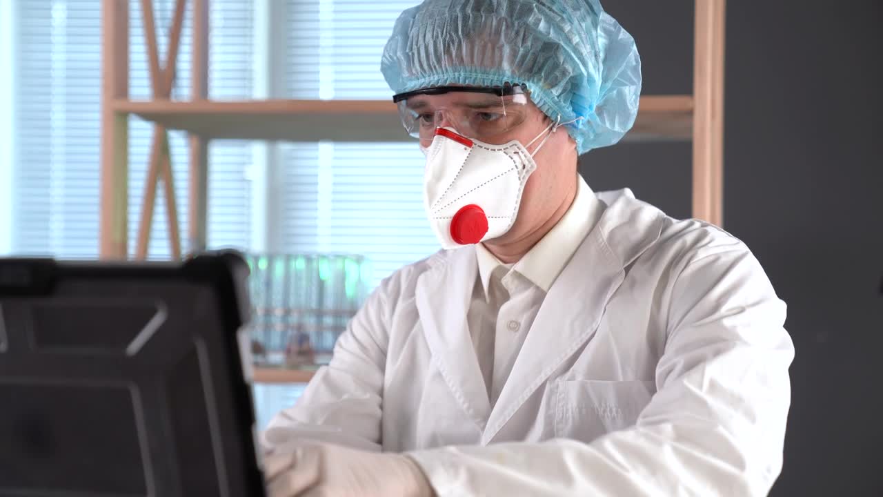 Stock Video Doctor Using A Facemask Typing On A Computer Live Wallpaper For PC - Free Download