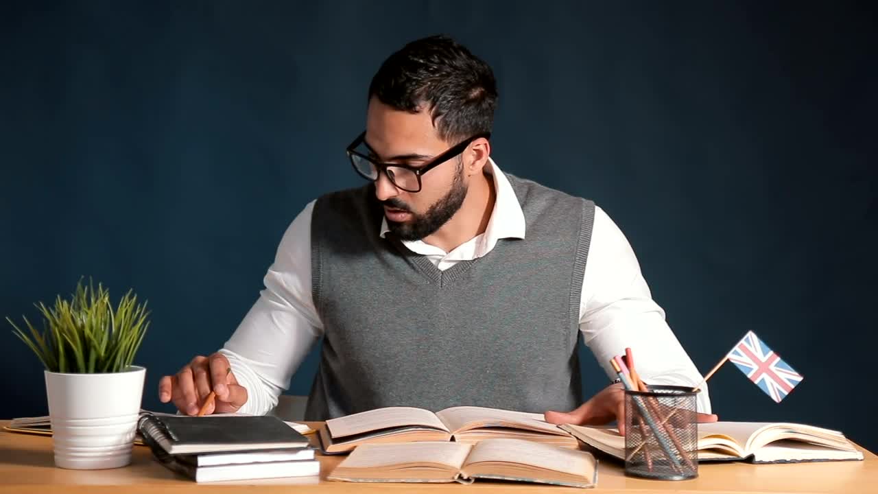 Free Video Stock teacher works at desk in classroom with chalkboard background Live Wallpaper - Free Download