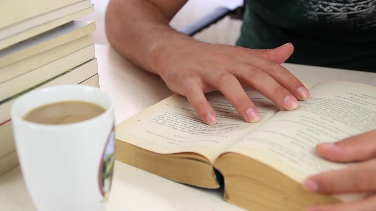 Stock Video Man Drinks Coffee From A Mug While Studying Animated Wallpaper - Free Download