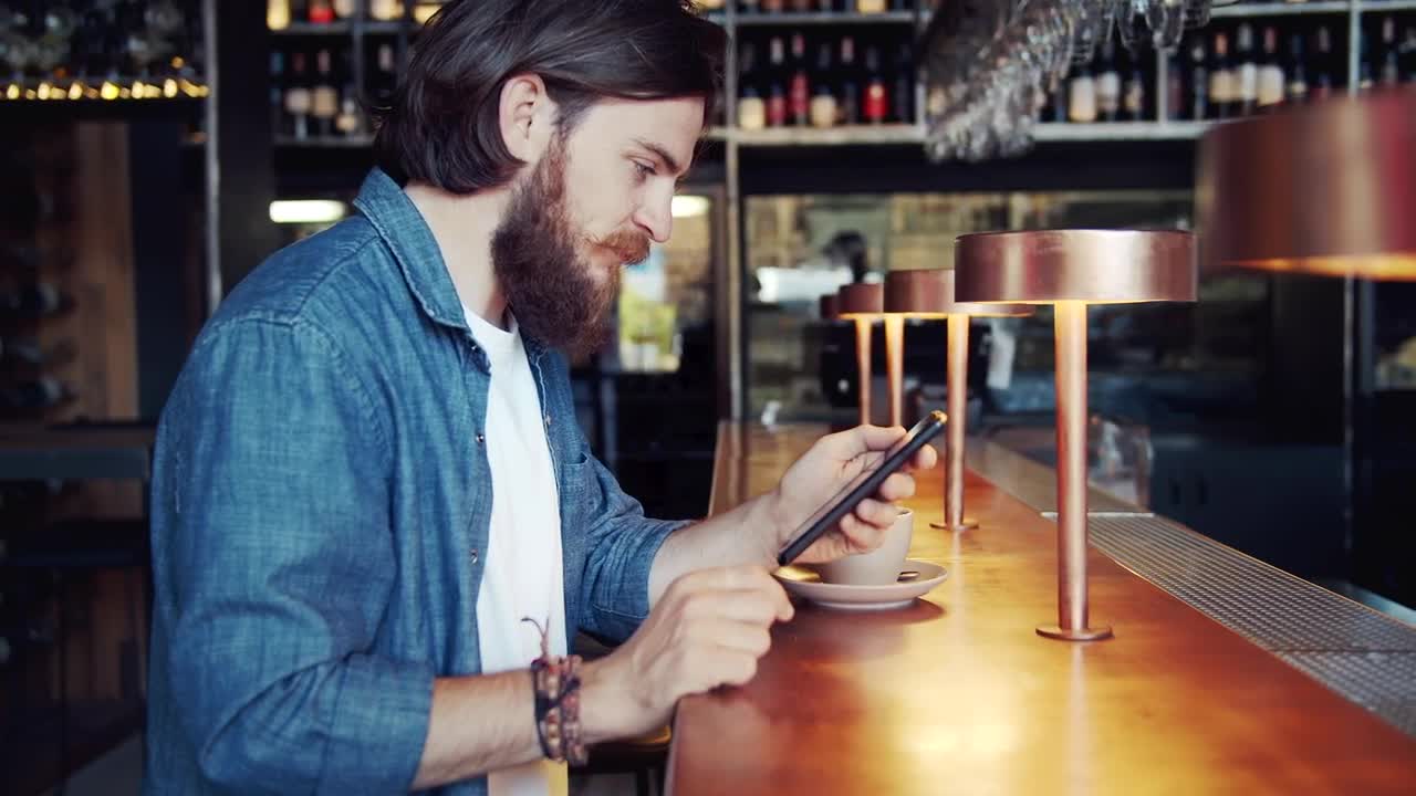Stock Video Bearded Man Uses Mobile App In Urban Bar Live Wallpaper For PC - Free Download