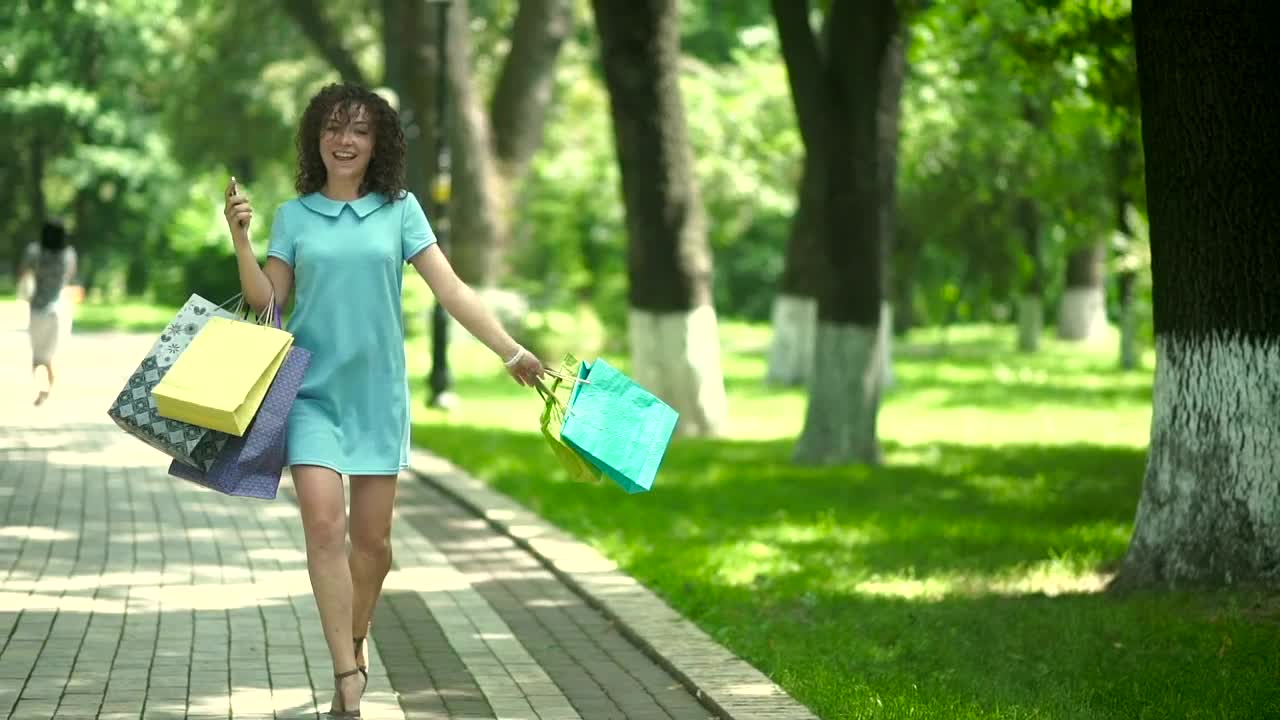Free Video Stock Stylish Woman Spins With Shopping Bags On Sunny Parkway Live Wallpaper - Free Download