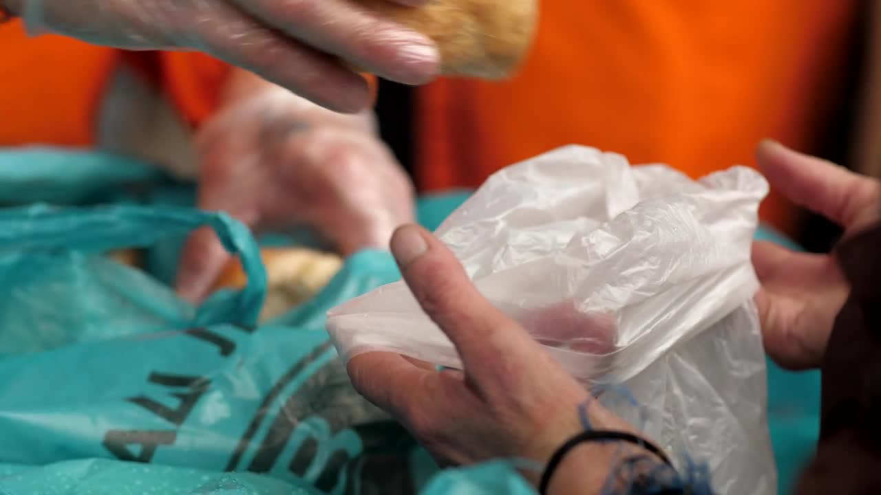 Stock Video Hands Of A Volunteer Gives Bread To Hungry People Animated Wallpaper - Free Download