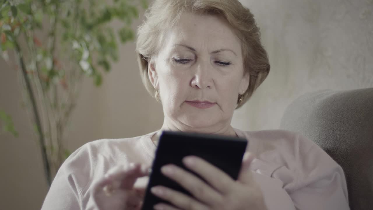 Stock Video Mature Woman Using An Electronic Reading Devic Animated Wallpaper - Free Download