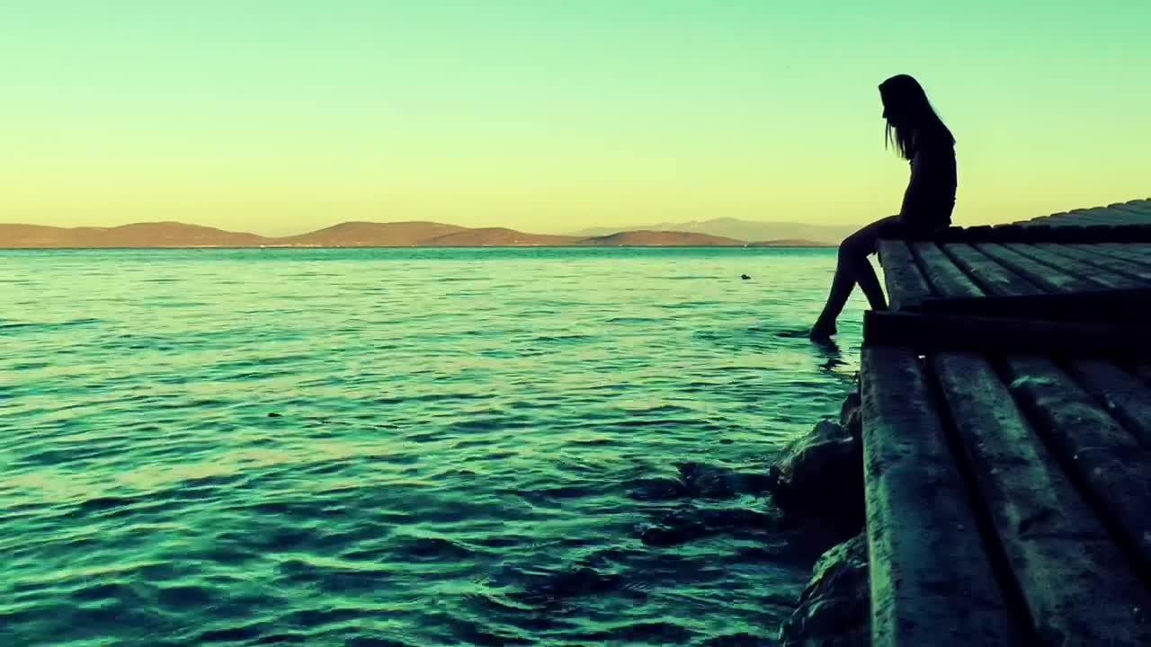 Free Video Stock the silhouette of a pensive woman contemplating the sea Live Wallpaper - Free Download