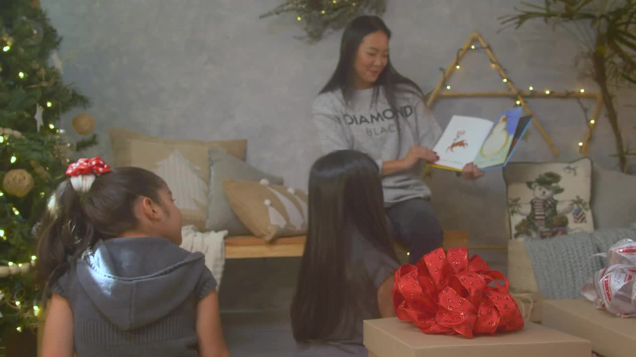 Stock Video Mother Reading A Book To Her Daughters At Christma Animated Wallpaper - Free Download