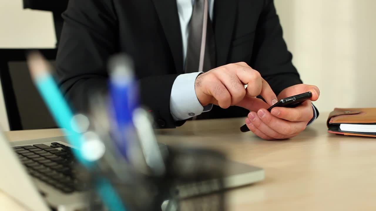 Stock Video Man In A Suit In His Office Using His Cellphone Animated Wallpaper - Free Download
