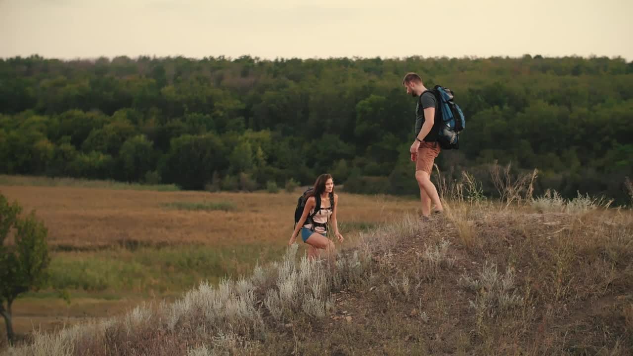 Stock Video Man Helps His Friend To Climb A Mound In Nature Animated Wallpaper - Free Download