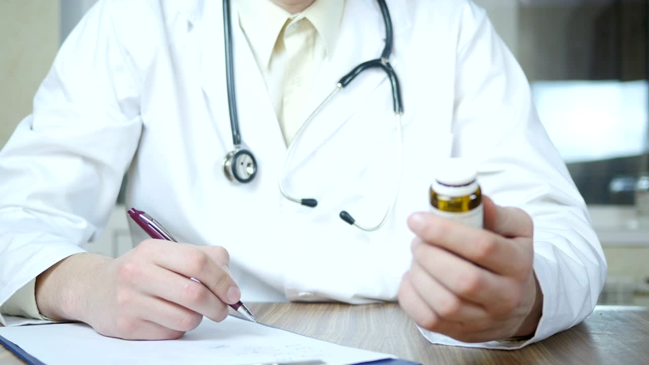 Stock Video Doctor Writing A Prescription Holding A Medicine Container Live Wallpaper For PC - Free Download