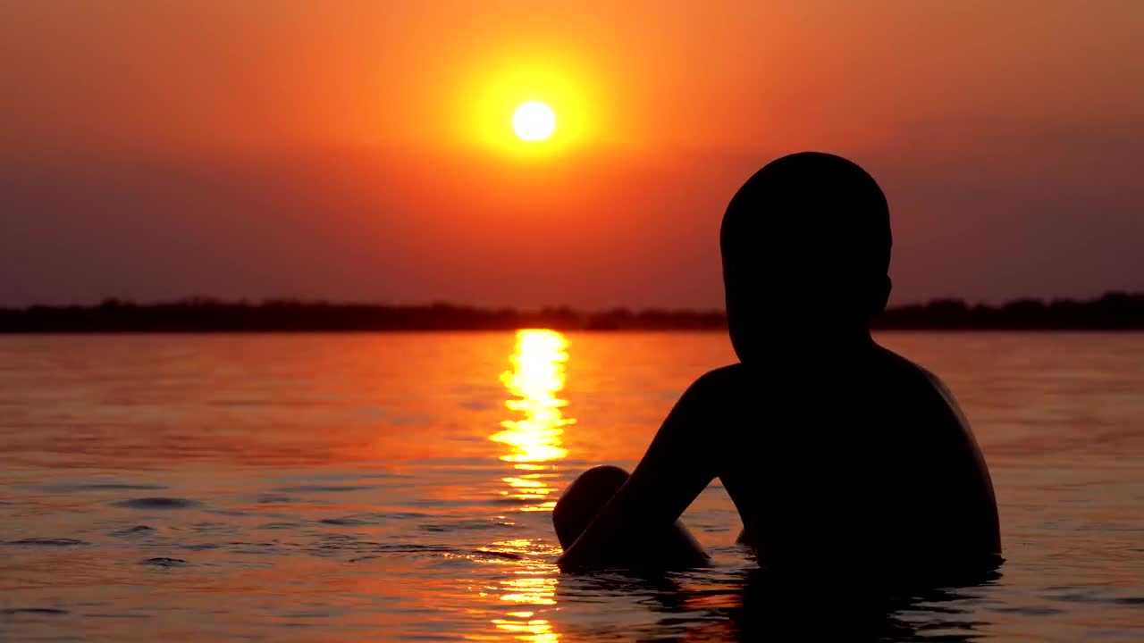 Free Stock Video Silhouette Of A Boy In The Sea At Sunset Live Wallpaper - Free Download