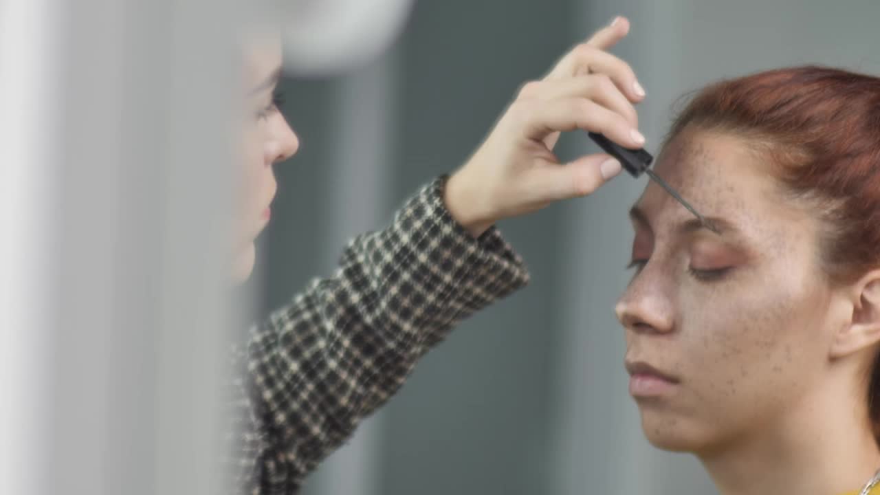 Stock Video Makeup Artist Putting Makeup On The Eyebrows Of A Young Animated Wallpaper - Free Download