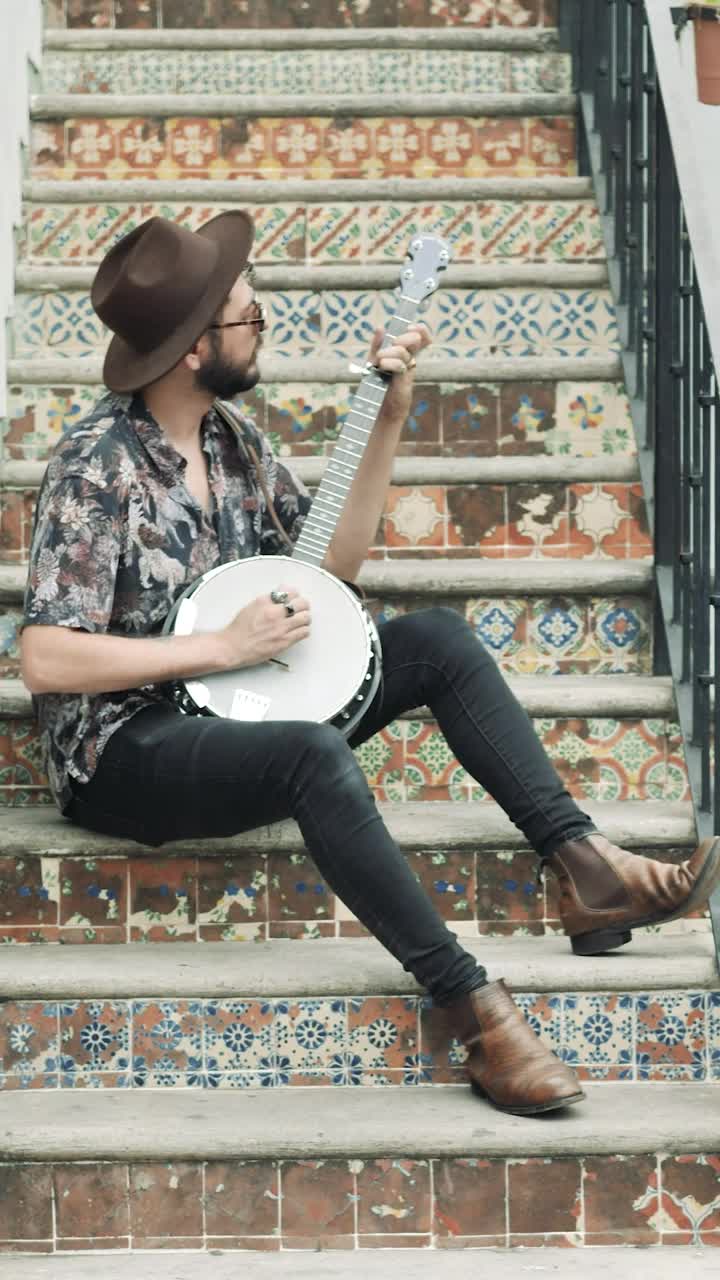 Stock Video Musician Sitting On An Old Ladder Playing His Banjo Live Wallpaper - Free Download