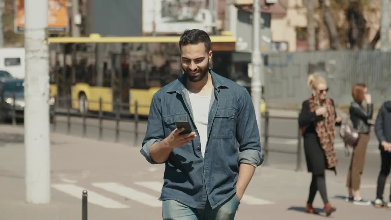 Stock Video Hopeful Man Smiles At Social Media While Walking Through City Animated Wallpaper - Free Download