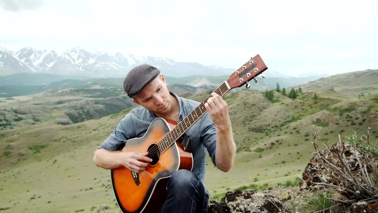 Stock Video Man Plays Acoustic Guitar On Ridge Above Mountain Landscap Animated Wallpaper - Free Download