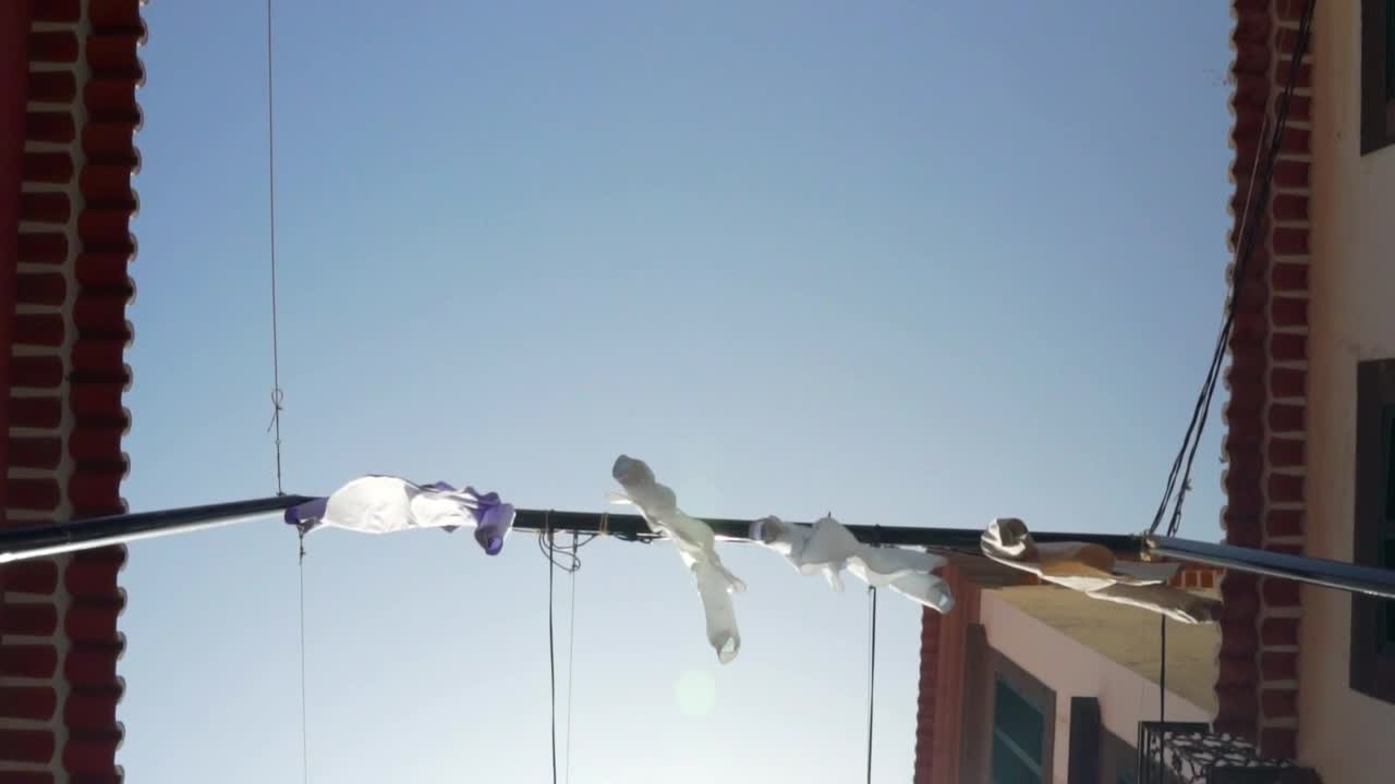 Free Video Stock tourist town street with shirts hung as decorations Live Wallpaper - Free Download
